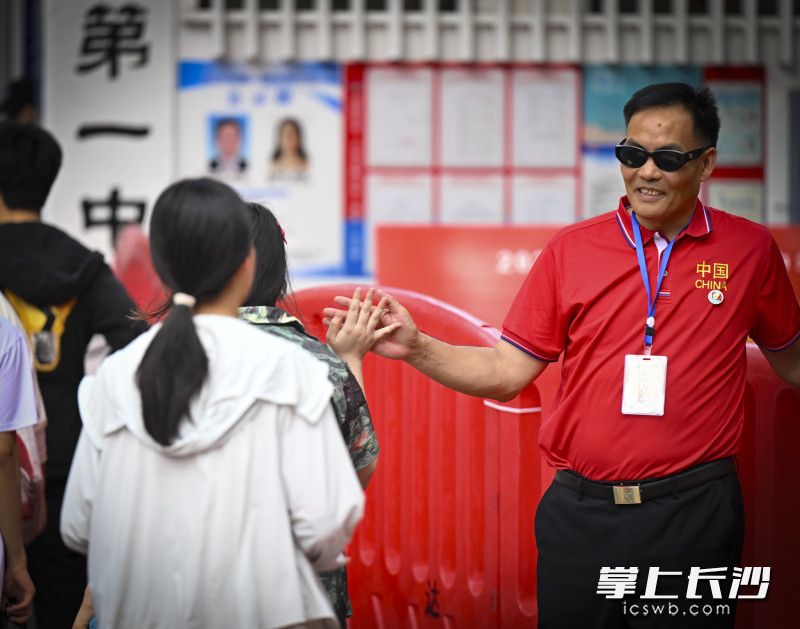 长沙市一中高考“掌门人”孙科长和考生击掌为考生加油鼓劲。