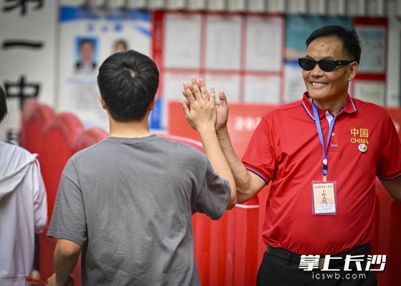 长沙市一中高考“掌门人”孙科长和考生击掌为考生加油鼓劲。