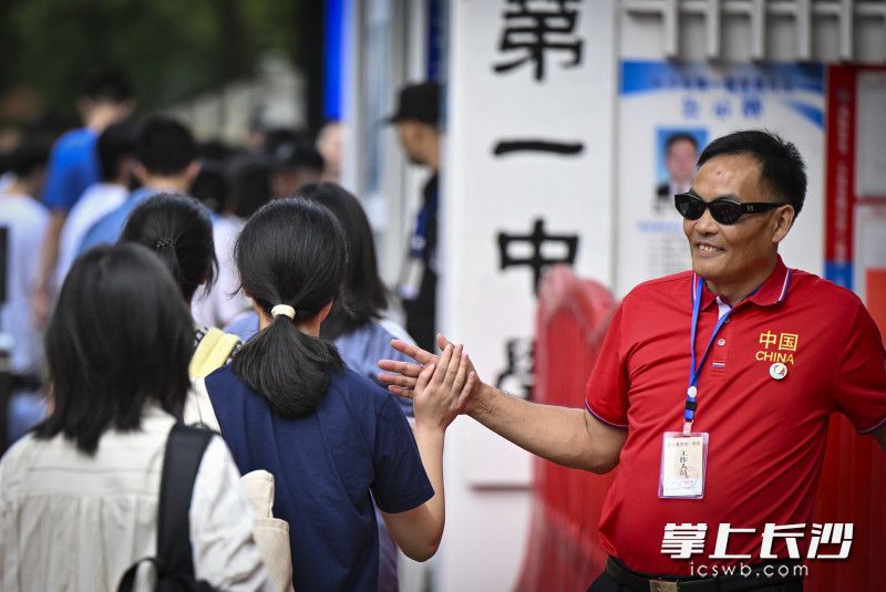 长沙市一中高考“掌门人”孙科长和考生击掌为考生加油鼓劲。