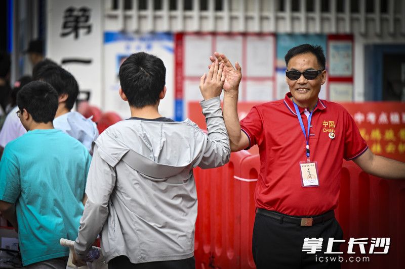 长沙市一中高考“掌门人”孙科长和考生击掌为考生加油鼓劲。