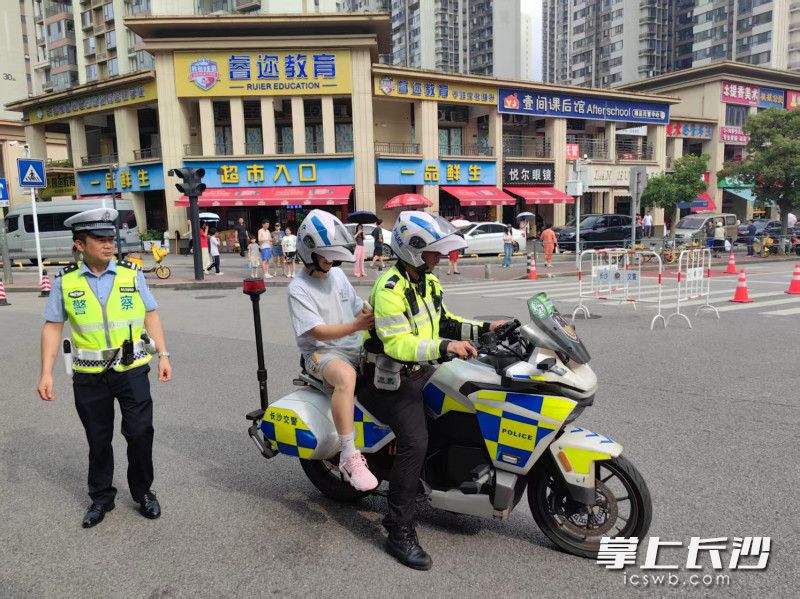 周南梅溪湖中学考点外，湘江新区交警送走错考场的考生。通讯员 欧阳珏 摄