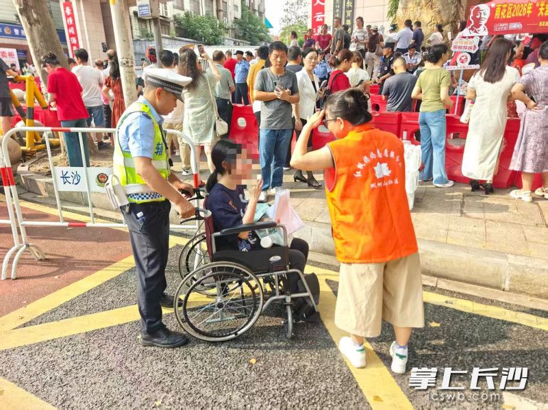 雨花交警与志愿者护送腿受伤考生进入考场。通讯员 尹文军 摄