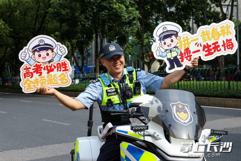2026年高考第一日，雅礼中学考点外，交警为考生送上祝福。均为长沙晚报全媒体记者 董阳 摄