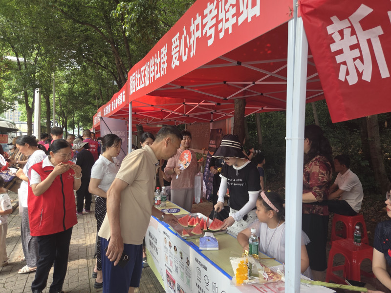 气温逐渐升高，湘园社区志愿者切好西瓜，分发给送考家长和现场志愿者。