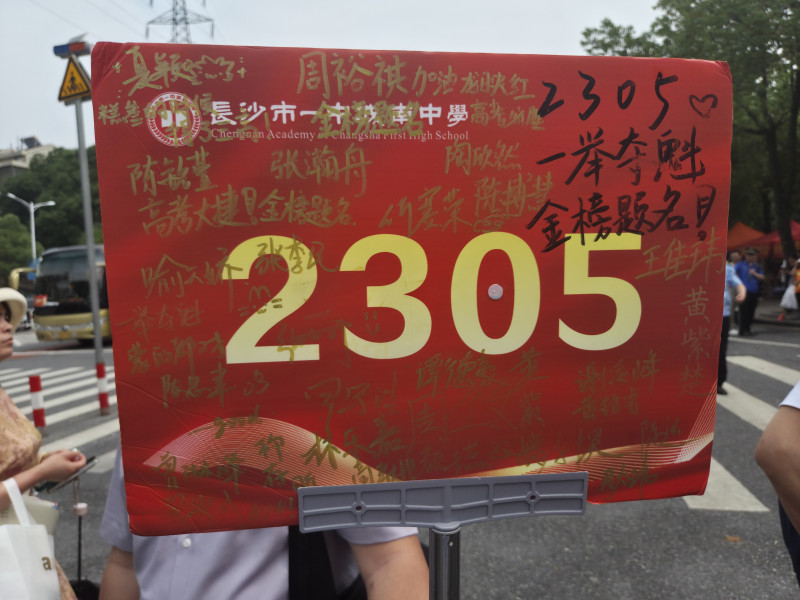 一块班级号牌上，写满了学生的签名和期许，也承载着老师对考生的祝福。