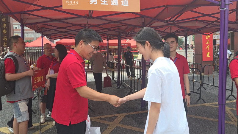 进场前，老师们站在考点门口与学生逐一握手，为他们加油鼓劲。