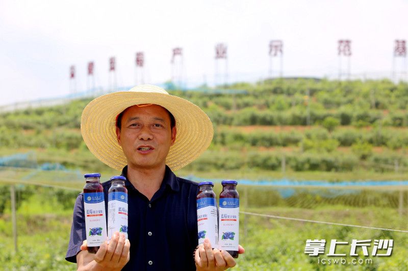 黄德良展示蓝莓生态园精深加工的蓝莓汁。均为长沙晚报全媒体记者 贺文兵 摄