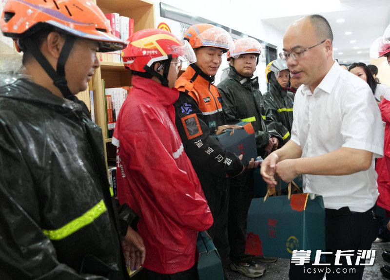 工作人员给外卖小哥送上粽子。