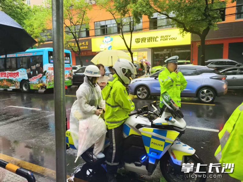 天心交管大队文源中队民辅警把雨伞给考生。