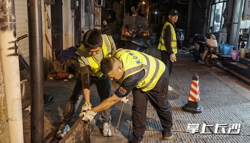 7日晚11时,天心区市政设施维护排渍科工作人员在小桥子巷检查雨水井淤积情况。均为长沙晚报全媒体记者 蒋志斌 摄 7日晚11时,天心区市政设施维护排渍科工作人员在小桥子巷检查雨水井淤积情况。均为长沙晚报全媒体记者 蒋志斌 摄