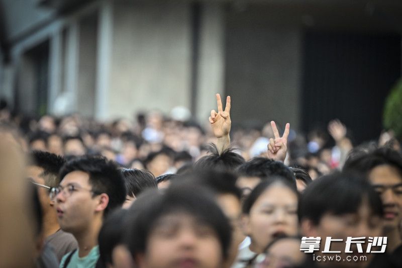 人群中的考生比出胜利的手势。