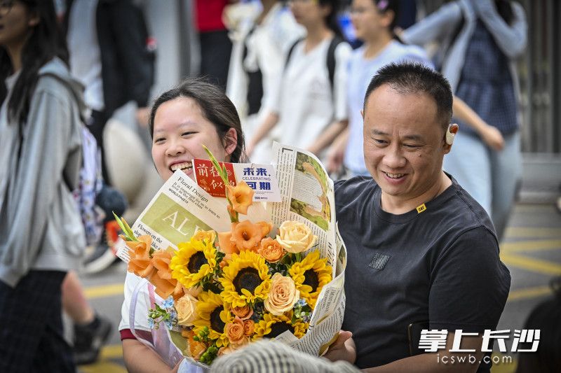 家长手捧鲜花迎接考试结束的孩子。 均为长沙晚报全媒体记者余劭劼摄