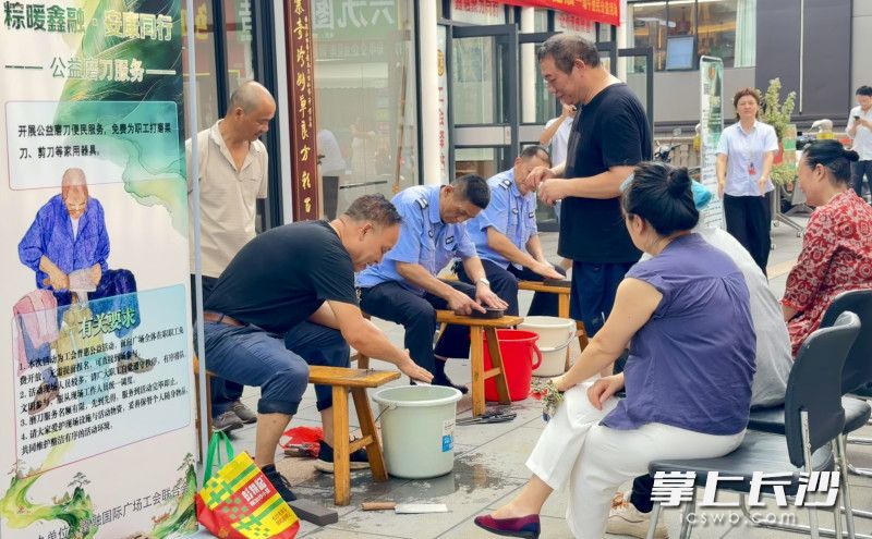 公益磨刀服务摊位前也颇为热闹，专业师傅免费为职工打磨菜刀、剪刀等家用器具。