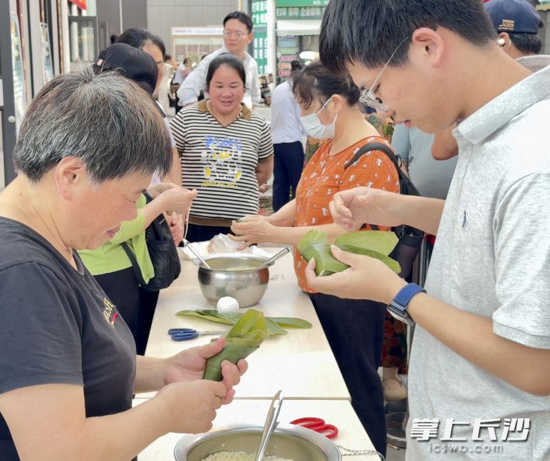 包粽体验区前排起长队，糯米、红枣、鲜肉等馅料整齐摆放，职工们围在桌前亲手体验。 均为长沙晚报全媒体记者周游摄