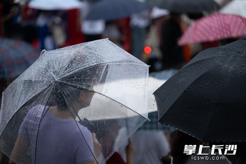 一位家长探头望校门。