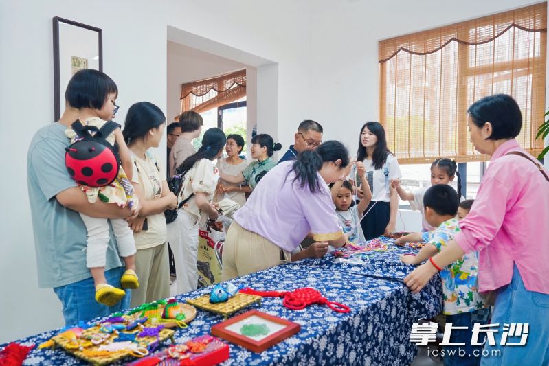 市民游客在长沙戏剧非遗展示中心学习中国结编织技艺。
