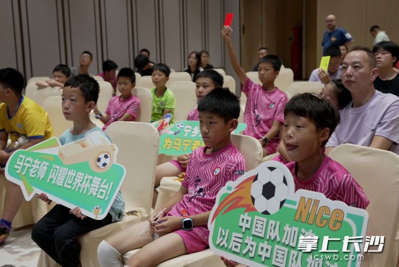 孩子们在观看比赛，灼灼目光里满含着对足球运动热爱。