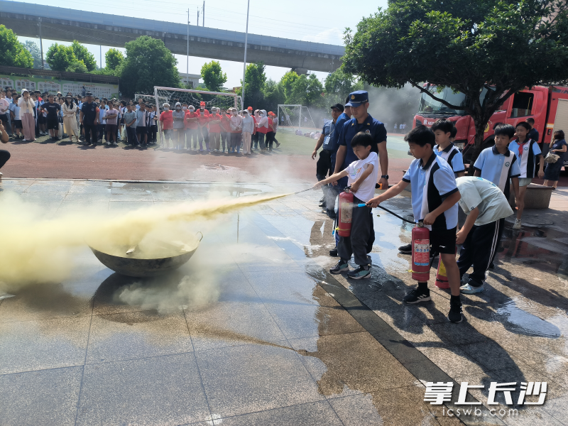 消防宣传员指导学生进行灭火实操。 长沙晚报通讯员 李铁应 摄