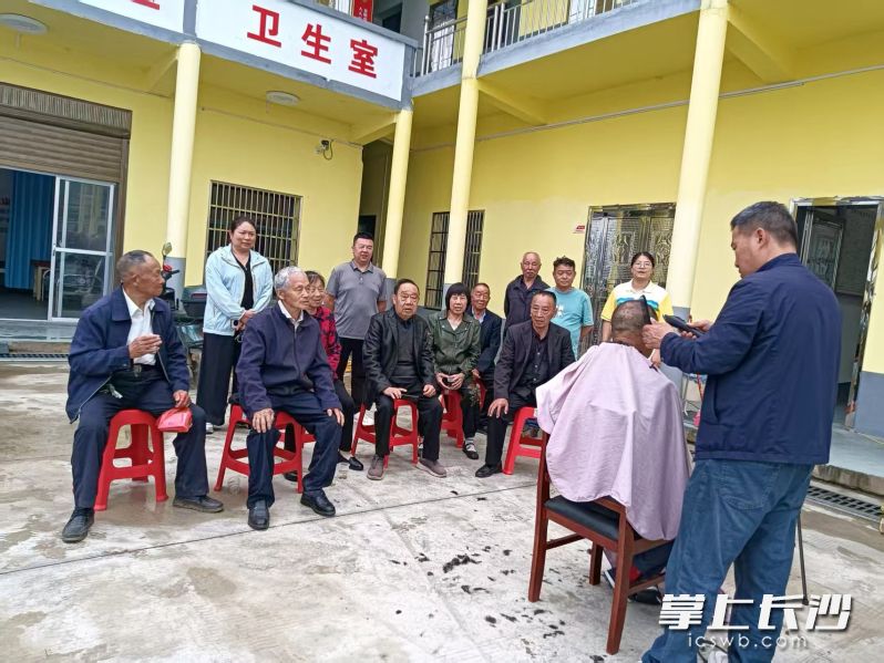 爱心人士为老年人提供免费理发服务。