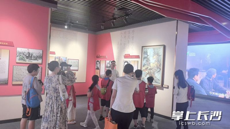 亲子家庭在潇湘忠魂专题陈列展厅了解雷锋、欧阳海的感人事迹。