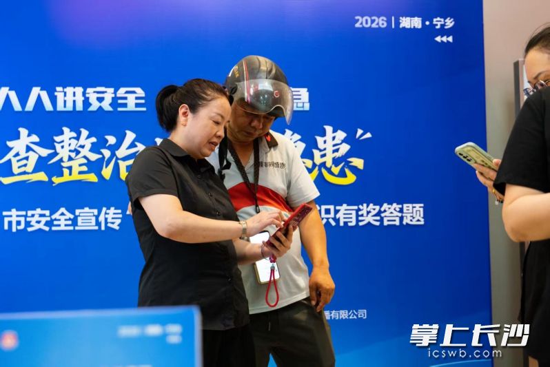 志愿者引导外卖骑手使用手机扫码参与答题。 均为长沙晚报全媒体记者张禹摄