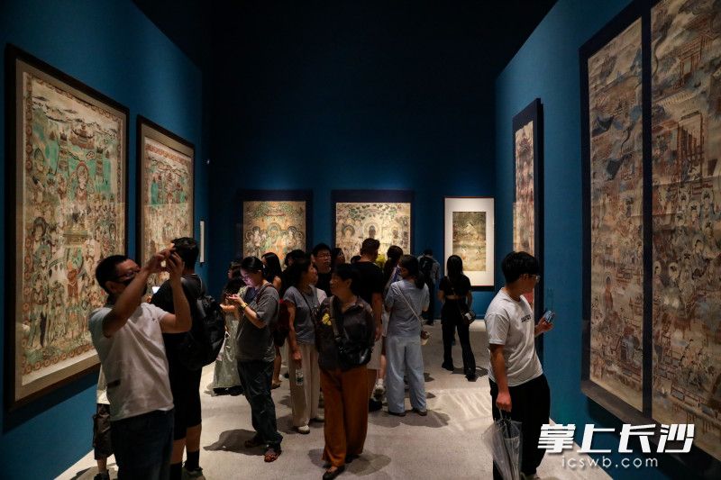 敦煌壁画首次集中现身湖南，观众在千年前壁画前啧啧兴叹。