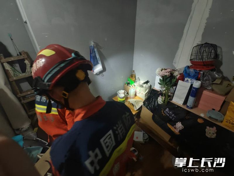 消防员正在处置钻进服装店的蛇。 长沙晚报通讯员 王磊 摄