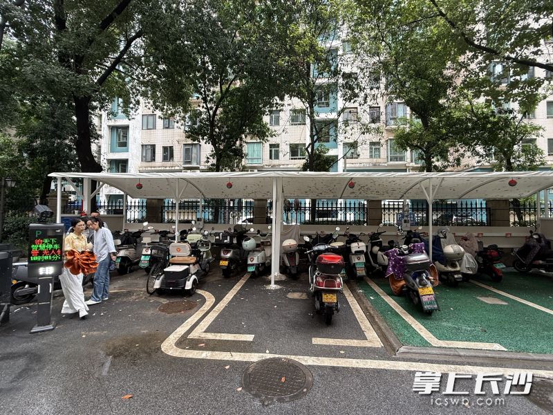 新华联家园小区东门3个机动车位被改造为电动自行车停车棚，配套智能充电桩和消防自动灭火球。 均为长沙晚报全媒体记者陈焕明摄