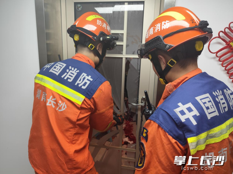 消防员正在破门营救。 长沙晚报通讯员 徐秋华 摄 消防员正在破门营救。 长沙晚报通讯员 徐秋华 摄