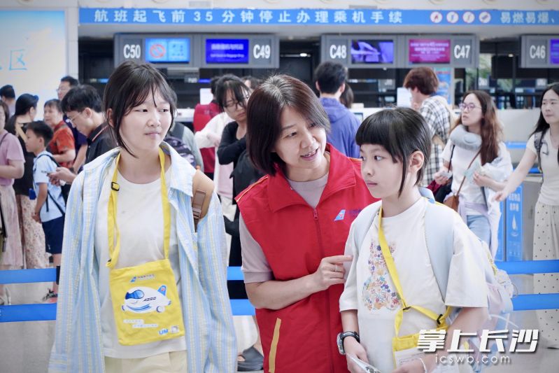 “红马甲”志愿者为旅客出行提供服务。