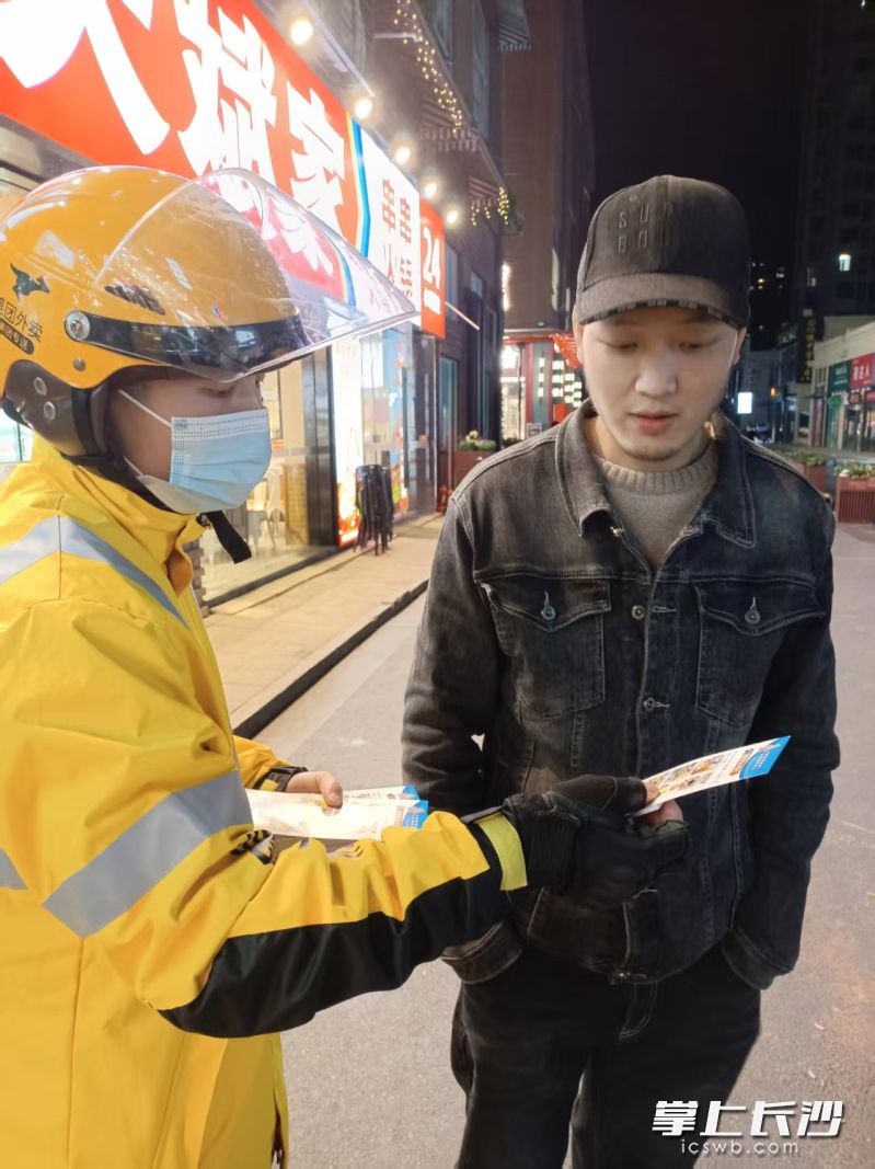 万素娟在送单途中向行人发放消防宣传单。 受访者供图