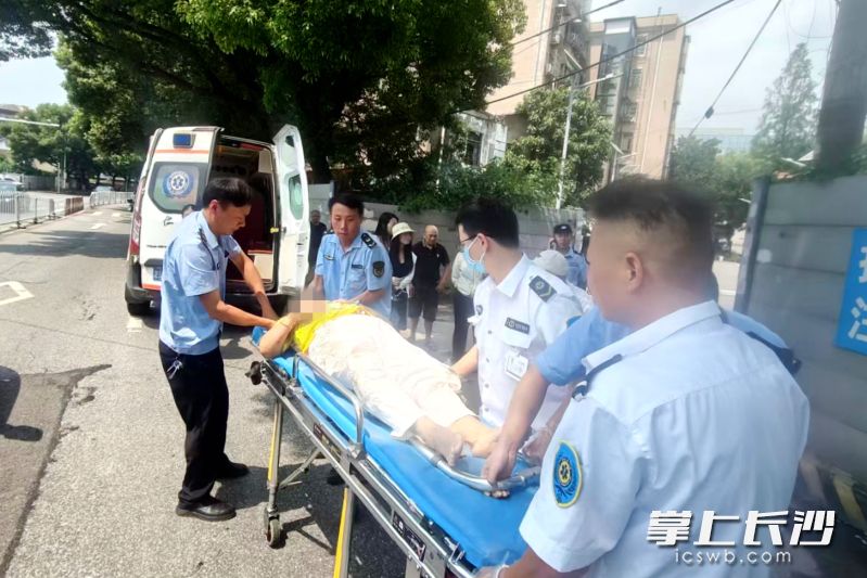 执法队员与急救人员配合将老人抬上担架，并一直护送至救护车上。