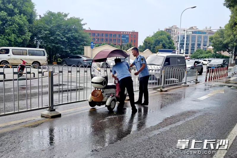 为防止二次事故，执法队员迅速将冲出的三轮车推到路边。