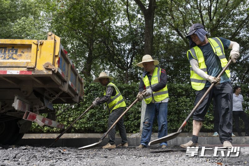 天心区青园街道友谊社区的刘家冲北路上，市政工人正在修复破损的路面。