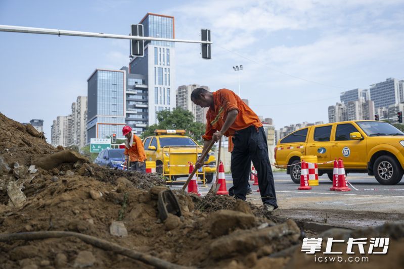 烈日当空，酷暑难耐。雨花区长托路与平阳南路交会处，15名身着橙色工装的市政工人顶着烈日在增设非机动车道。 均为长沙晚报全媒体记者黄启晴摄