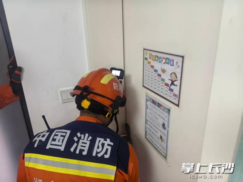 消防员正在破门营救。 长沙晚报通讯员 毛宏东 摄
