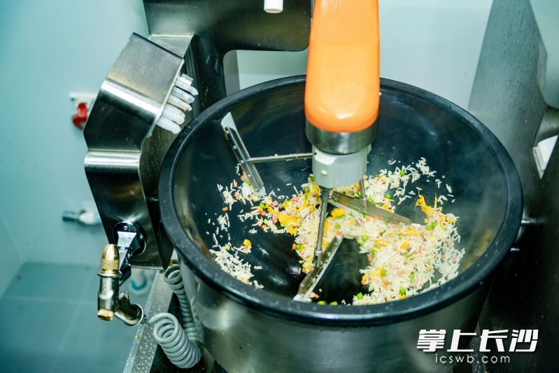 随着程序推进，机器人自动完成翻炒、调味、收汁等工序。