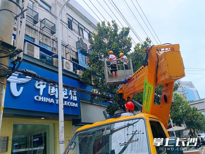 施工人员用云梯车作业拆除遮窗广告。