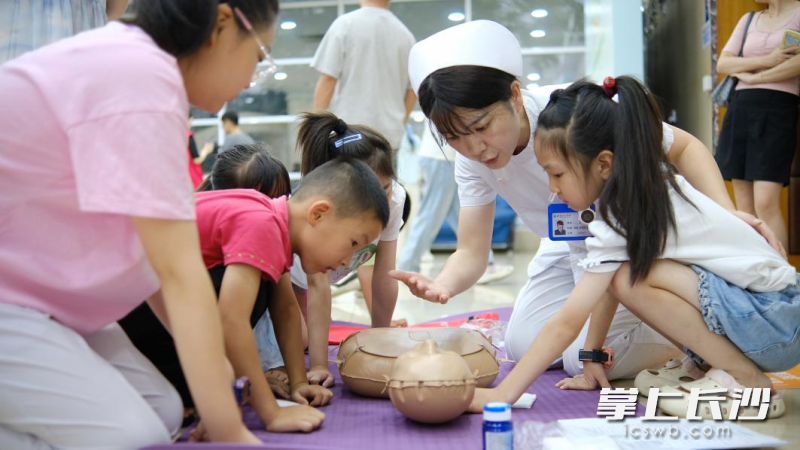护士老师手把手向小学员讲解心肺复苏的实操要领。
