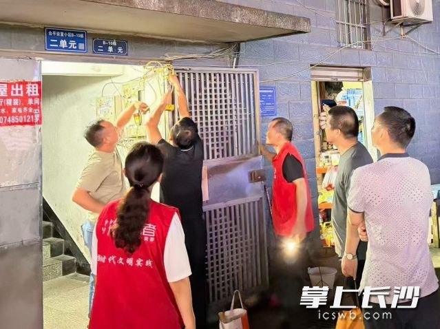 工作人员正在楼栋排查隐患。 工作人员正在楼栋排查隐患。