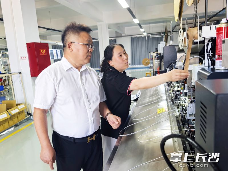 在长沙瑞良电子车间里，谢铁良（左）巡检流水线，指导工人规范操作。 长沙晚报全媒体记者 张禹 摄