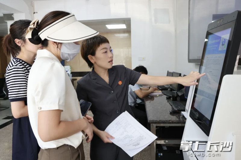 长沙法院积极推广示范文本应用，图为岳麓区法院工作人员指导当事人使用要素式起诉状。法院供图