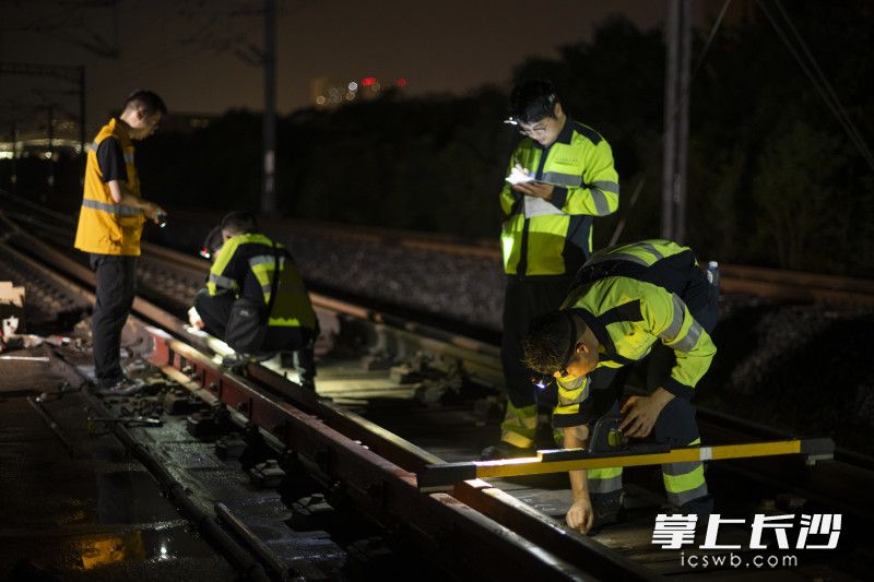 作业人员对放置的铁轨进行详细测量调整。
