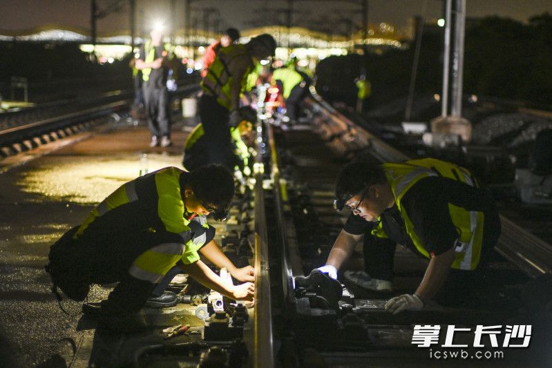 施工人员有条不紊的依次拆除换轨地段前后的扣件。