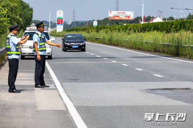 高速公路执法人员正在记录一处路面坑槽。 均为长沙晚报全媒体记者董阳摄