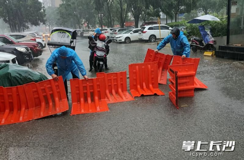 新一轮强降雨来袭，物业工作人员立马安装挡水板，以防雨水倒灌。