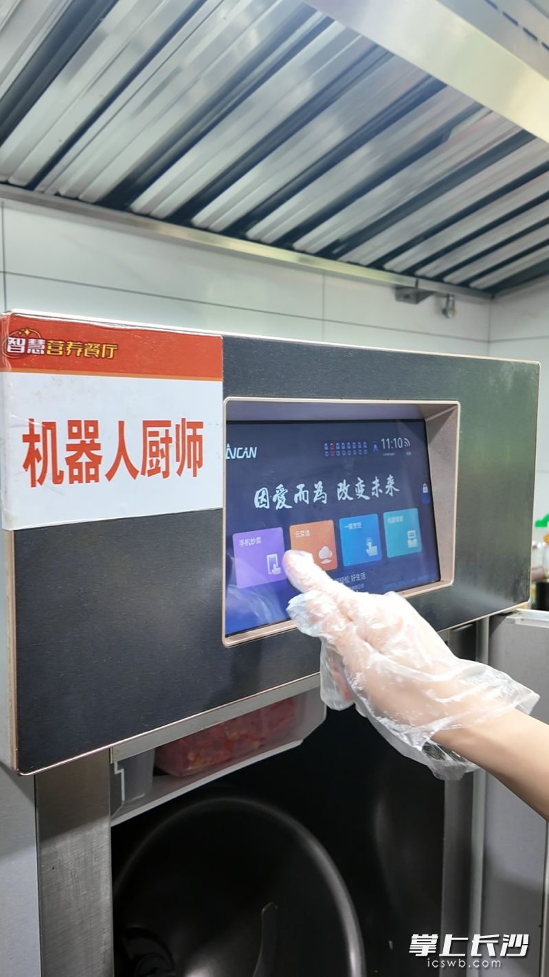 工作人员正在点击使用机器人厨师菜谱。 均为长沙晚报实习生杨龙杰摄