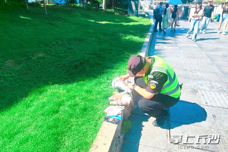 7月31日，在枫林一路上，新区城管队员何起舟、熊成缘巡查发现市民遗失的背包，并在14分钟内将财物归还失主。均为 通讯员 冯莹洁 供图