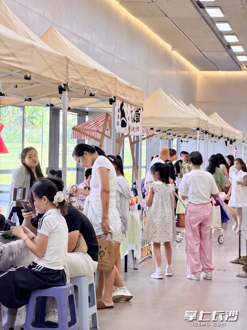 市民游客穿梭在摊位之间，享受一段悠闲的夏日时光。