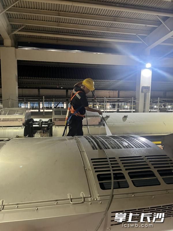 在车顶使用高压水枪逐台冲洗泠凝器。
